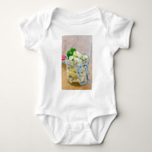 Potato salad in a jar on wooden baby bodysuit