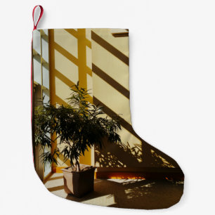 Potted green plant on brown wooden table small christmas stocking