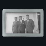President John Kennedy & Brothers American Camelot Belt Buckle<br><div class="desc">The sun beat down on the three Kennedy brothers as they stood beneath the familiar white portico of the White House. President John F. Kennedy, the eldest, leaned against a pillar, a wry smile playing on his lips. His younger brothers, Robert and Ted, stood beside him, their faces a mix...</div>