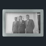 President John Kennedy & Brothers American Camelot Belt Buckle<br><div class="desc">The sun beat down on the three Kennedy brothers as they stood beneath the familiar white portico of the White House. President John F. Kennedy, the eldest, leaned against a pillar, a wry smile playing on his lips. His younger brothers, Robert and Ted, stood beside him, their faces a mix...</div>