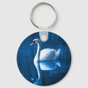 Pretty white swan floating on a blue lake keychain