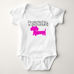Protected by a Dachshund (pink) Baby Bodysuit