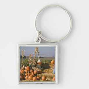 Pumpkin display with hay bales and scarecrows keychain