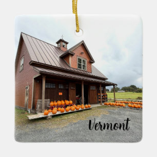 Pumpkins by a small farm building ceramic ornament
