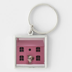 Puppy peering out of doll's house keychain