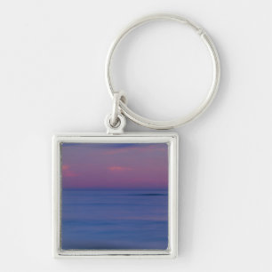 Purple-coloured sunrise on ocean shore keychain