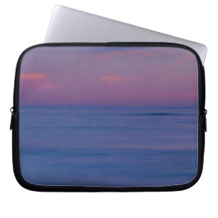 Purple-coloured sunrise on ocean shore laptop sleeve