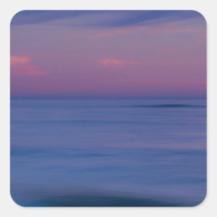 Purple-coloured sunrise on ocean shore square sticker