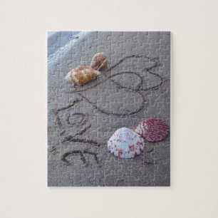 Puzzle 2 coeurs dans le sable avec des coquilles avec