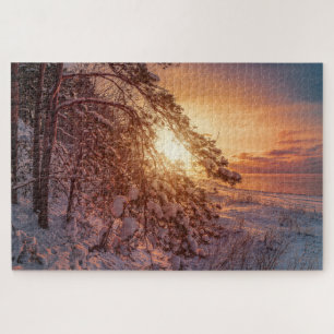 Puzzle Coucher de soleil sur la mer et pinède neigeux puz
