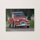 Une vieille voiture rouge Citroen 2CV avec une fem