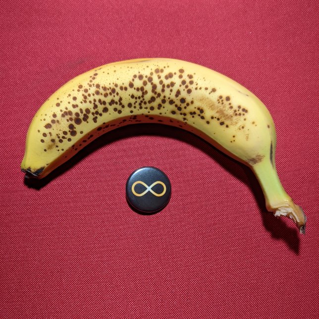 Radiant Gold Autism Awareness Infinity Knot 1 Inch Round Button (Small button with banana for scale.)