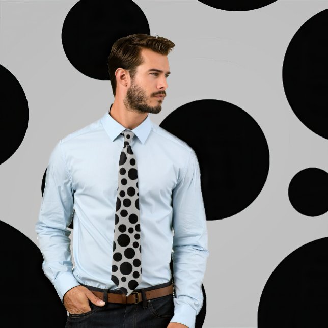 Random Black Polka Dot Pattern on Light Grey Tie (Man weats necktie featuring randomly sized polka dots in black on gray. Background matches tie.)