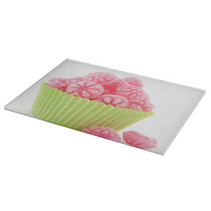 Raspberry tasty candy sweets in green cup cake cutting board