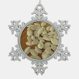 Raw pumpkin seeds on wooden table snowflake pewter christmas ornament