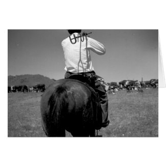Rear view of a cowboy on a horse with two brands U