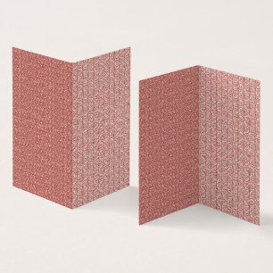 Red and pink textiles laid over a patterned rug wi