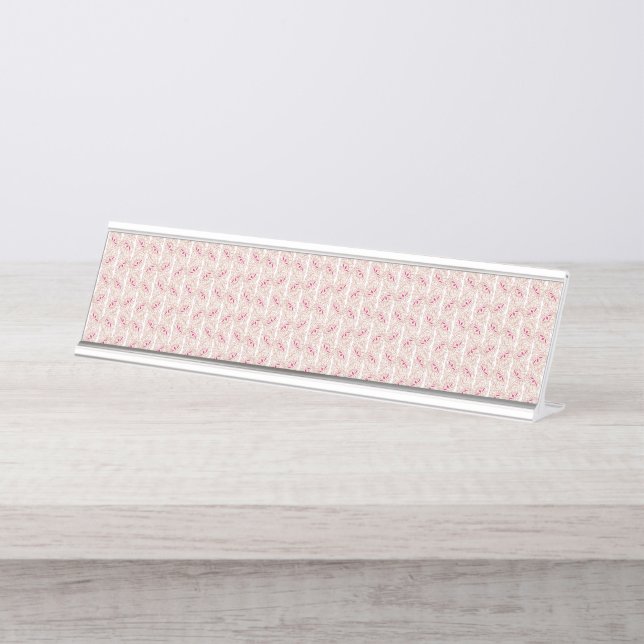 Red and pink textiles laid over a patterned rug wi desk name plate (Front)