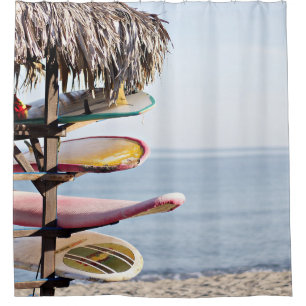 Red and white surfboard in brown wooden rack