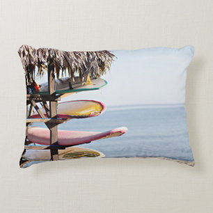 Red and white surfboard in brown wooden rack accent pillow
