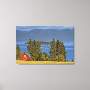 Red barn sits along scenic Flathead Lake near Canvas Print