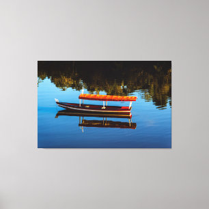 Red Canoe Reflection on Still Blue Water Canvas Print