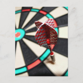 Red chequered dart on dartboard postcard