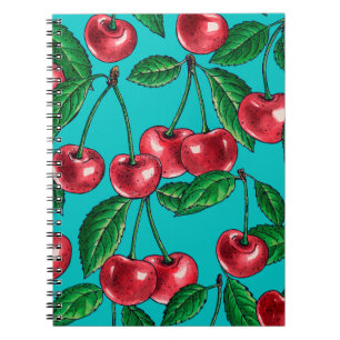 Red cherries on turquoise notebook