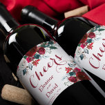 Red Christmas botanical floral cheers wedding Wine Label<br><div class="desc">Cheers calligraphy script and watercolor red burgundy and white peony flowers bouquets with pine green seasonal fir branches, red berries, and foliage together with bride and groom names over a clear white background making an inspired personalized wine label for your Christmas rustic elegant floral wedding or other winter seasonal celebrating...</div>