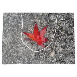 Red fall leaf in rain on grey textured road large gift bag