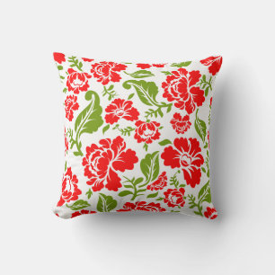 Red flowers with green leaves create a vibrant throw pillow