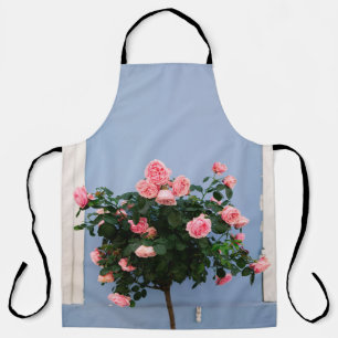 Red flowers with green leaves on blue wall apron
