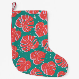 Red monstera leaves on green seamless pattern. Tre Small Christmas Stocking