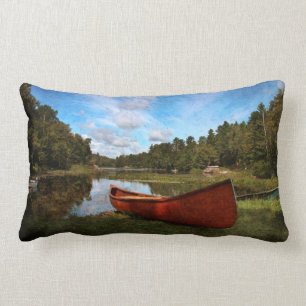 Red rustic canoe on a lake bank lumbar pillow