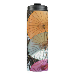 Red umbrella on green tree thermal tumbler