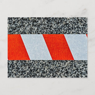 Red warning tape across granite stone postcard