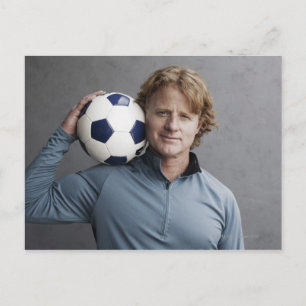 Redhead holding a soccer ball on his shoulder postcard