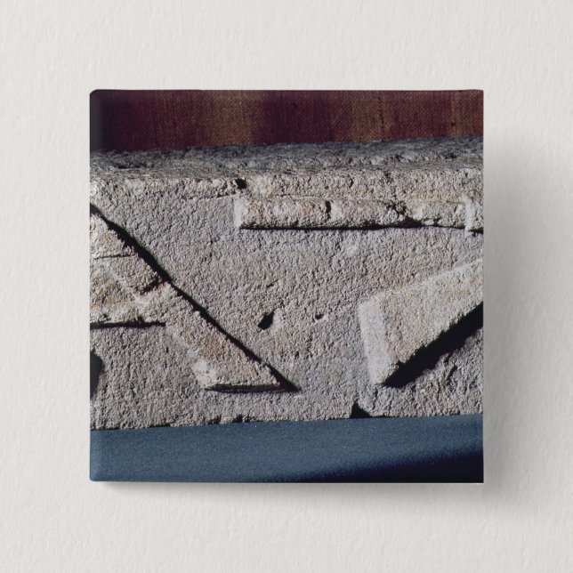 Relief depicting a stonemason's instrument 2 inch square button (Front)