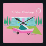 Retro Pink Palm Springs Acrylic Wall Clock<br><div class="desc">Between the pink background, turquoise mid century modern home, and the classic 1950s car, this design couldn’t be more Palm Springs if it said it in the clouds. Oh, wait, it does say it in the clouds! The blue and teal stone of the house is offset by the sputnik light...</div>
