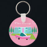 Retro Pink Palm Springs Button Keychain<br><div class="desc">Between the pink background, turquoise mid century modern home, and the classic 1950s car, this design couldn’t be more Palm Springs if it said it in the clouds. Oh, wait, it does say it in the clouds! The blue and teal stone of the house is offset by the sputnik light...</div>