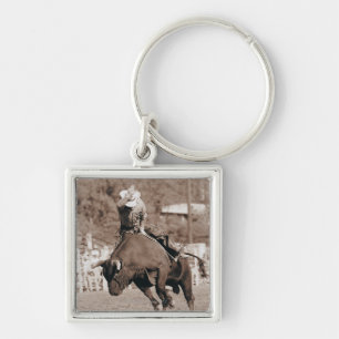 Rider about to fall off bucking bull keychain