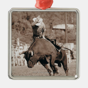 Rider about to fall off bucking bull metal ornament