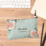 Rose gold floral sage green bridesmaid accessory pouch<br><div class="desc">A sage green background,  black and golden text. Decorated with watercolored rose gold roses,  eucalyptus greenery and golden sprigs. 
Personalize and add the name of your bridesmaid.</div>