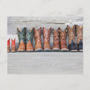 Row of cowboy boot on porch of log cabin postcard