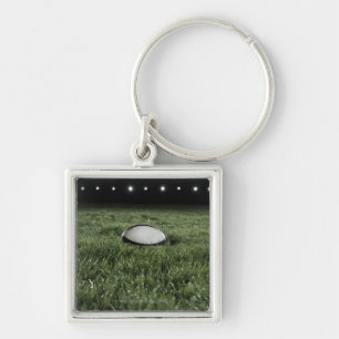 Rugby ball sitting on the grass pitch of a keychain