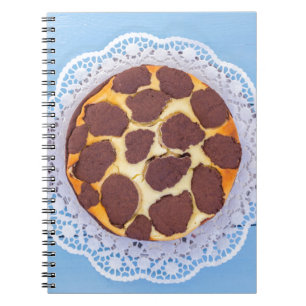 Russian chocolate cheesecake on a blue wooden back notebook