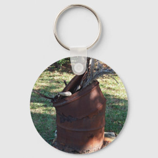Rusted garbage can in grassy landscape keychain