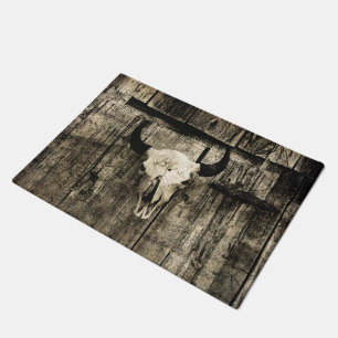 Rustic buffalo skull with horns on a barn doormat