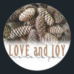 Rustic Holiday Love and Joy Pine Cone Classic Round Sticker<br><div class="desc">Festive,  rustic pine cones accentuate this classic,  elegant design wishing holiday Love and Joy.</div>
