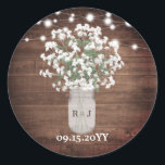 Rustic Monogram Mason Jar Vase Lights Wedding Classic Round Sticker<br><div class="desc">This design features dainty watercolor baby's breath flowers in a monogrammed mason jar vase on a rustic wood background with string lights. Click the customize button for more flexibility in modifying the text or moving the graphics! Variations of this design as well as coordinating products are available in our shop,...</div>
